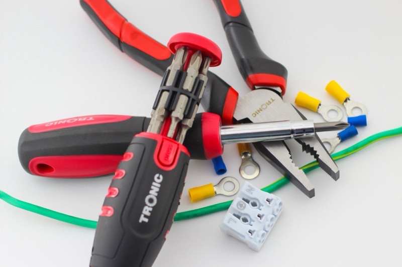 Screwdrivers, pliers, cable and connectors laid out